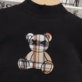 Chica Pre-adolescente De Camiseta Con Cuello Alto Y Diseno De Oso De Caricatura, Ademas De Falda Plisada De Cuadros