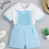 Conjunto de verano para bebe nino: camiseta de manga corta con cuello muneca y detalle de ribete contrastante y pantalones cortos con tirantes y detalles de cinta